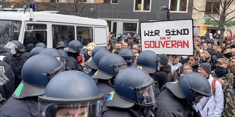Polizisten auf einer Demo in schwerer Schutzkleidung und Helmen